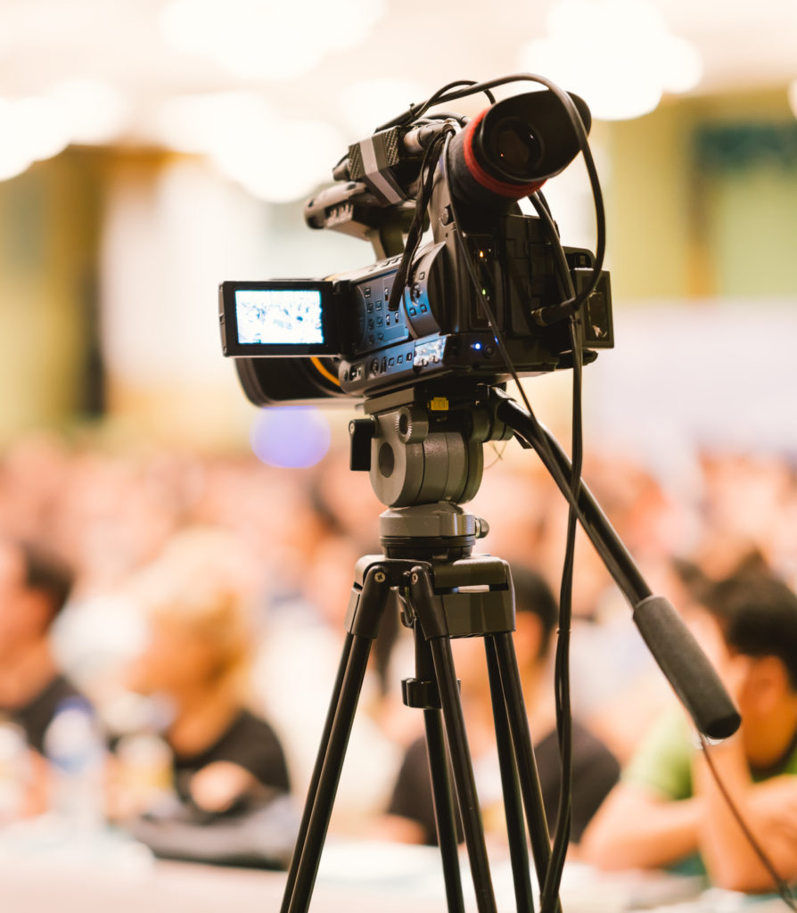 Video camera set record audience in conference hall seminar event. Company meeting, exhibition convention center, corporate announcement, public speaker, journalism industry, or news reporter concept