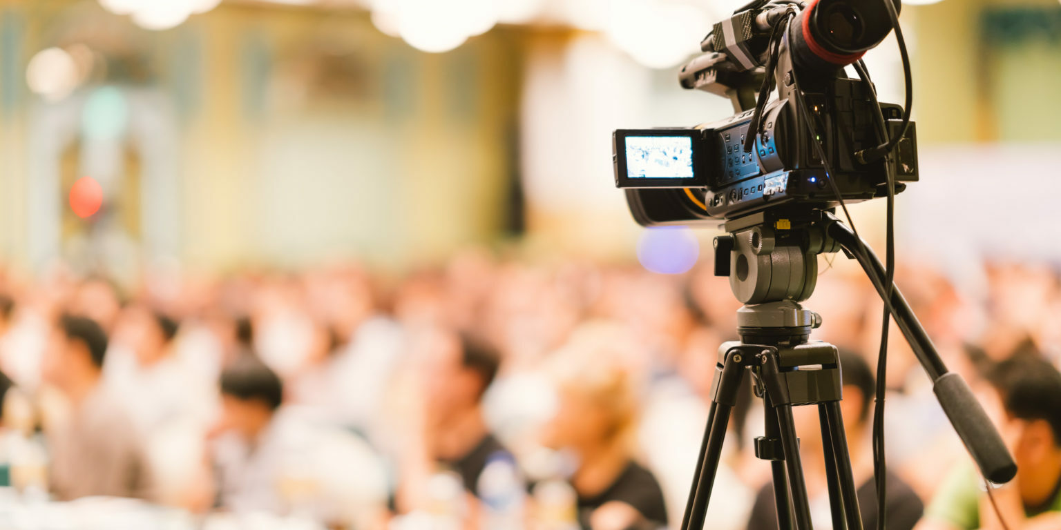 Video camera set record audience in conference hall seminar event. Company meeting, exhibition convention center, corporate announcement, public speaker, journalism industry, or news reporter concept