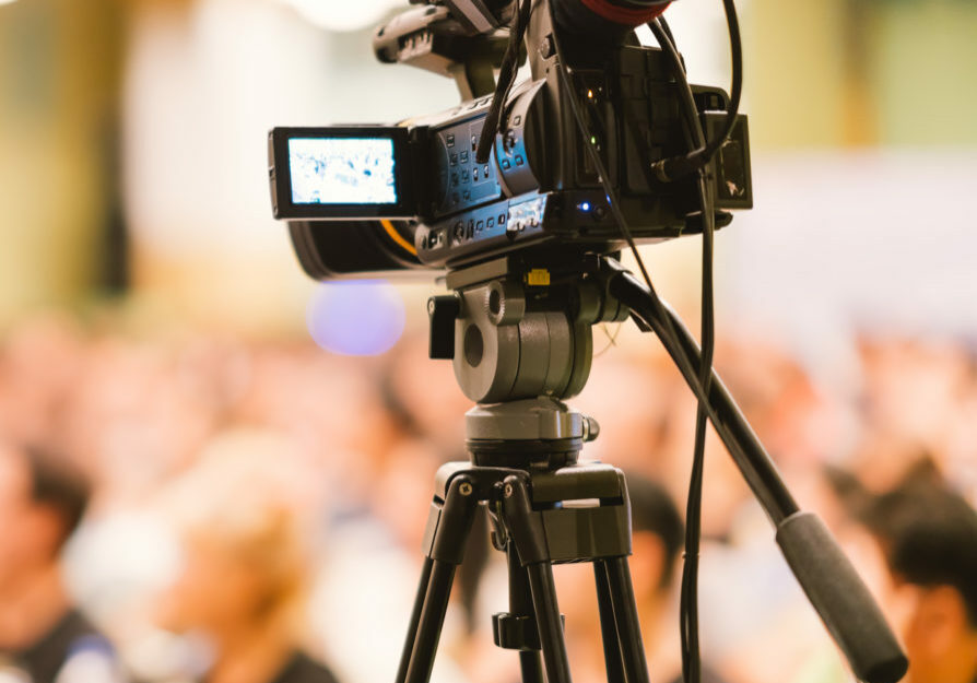 Video camera set record audience in conference hall seminar event. Company meeting, exhibition convention center, corporate announcement, public speaker, journalism industry, or news reporter concept