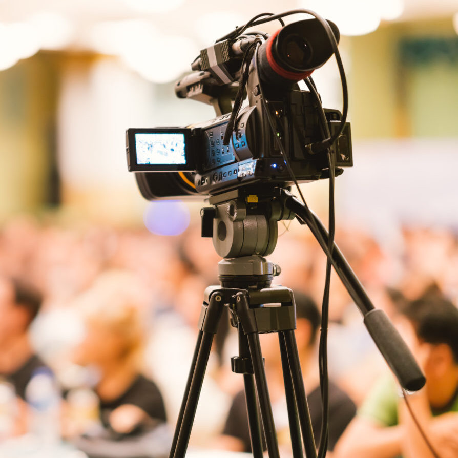 Video camera set record audience in conference hall seminar event. Company meeting, exhibition convention center, corporate announcement, public speaker, journalism industry, or news reporter concept