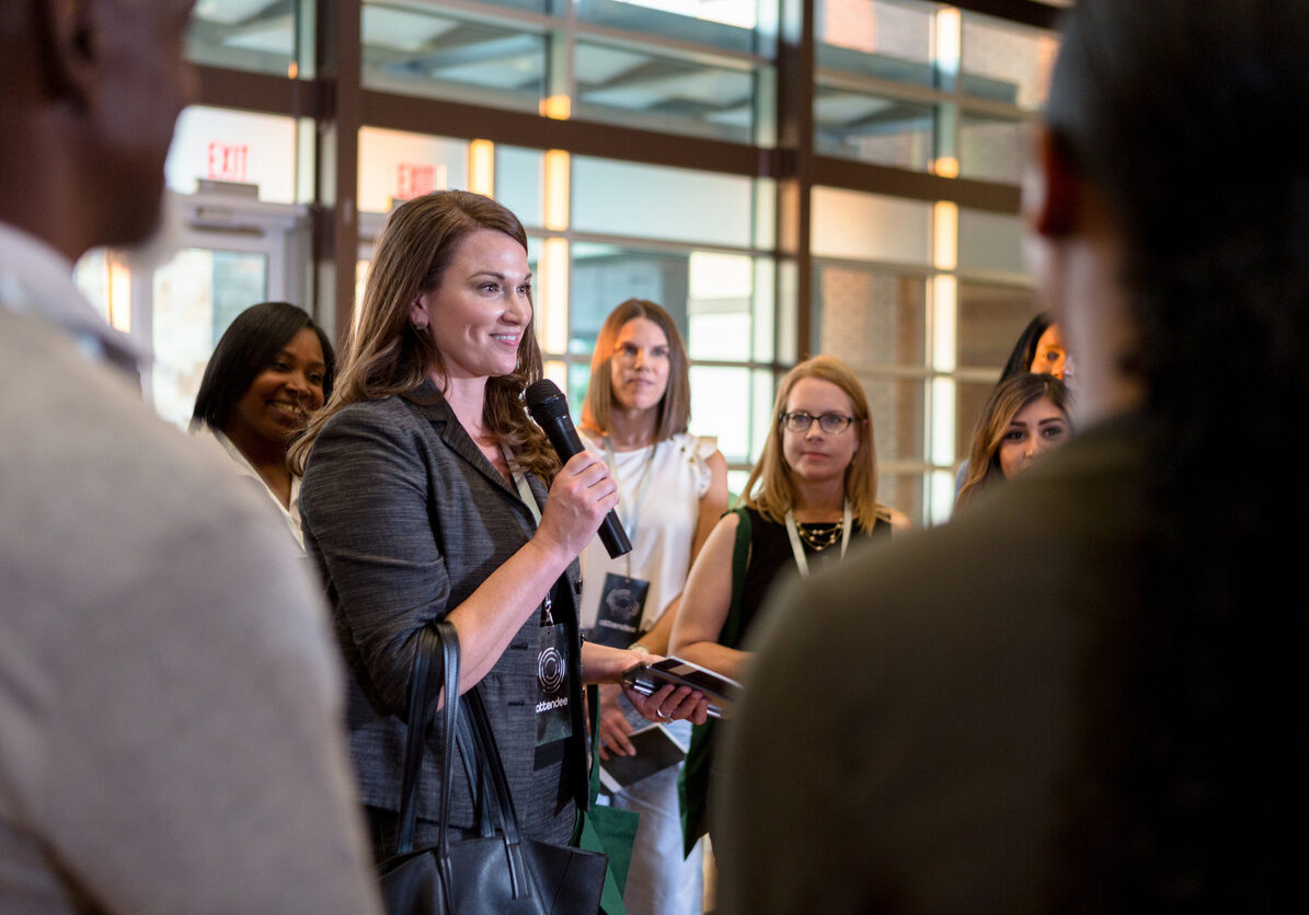 Confident conference speaker answers questions Cheerful mid adult business conference speaker gestures as she answers questions during a Q&A portion of the conference.